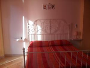um quarto com uma cama com um cobertor vermelho em Casa Del Padrino em Ispica