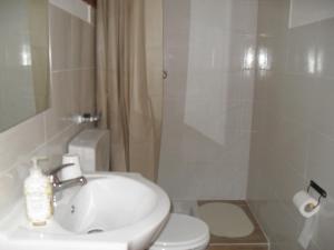 uma casa de banho com um lavatório, um chuveiro e um WC. em Casa Del Padrino em Ispica
