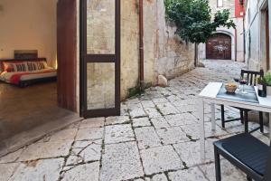 an alley with a door and a table and a couch at B&B Affittacamere Del Teatro in Brindisi