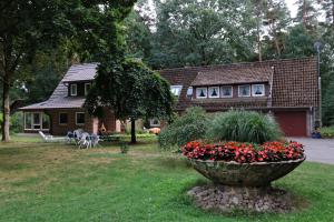 a house with a yard with a large pot of flowers at Ferienwohnungen / Ferienhaus Wahlers in Bispingen