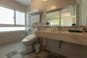 a bathroom with a sink and a toilet and a mirror at Sea Dragonfly in Yanliau