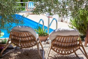 two chairs sitting next to a swimming pool at Villa Ana in Makarska