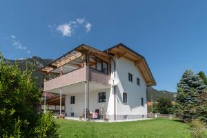 a large white house with a wooden roof at Apartment Gehrenspitze in Reutte