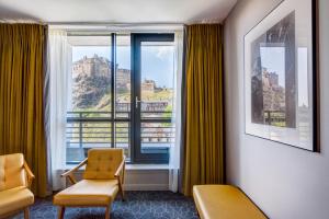 um quarto com uma janela com vista para um castelo em Apex Grassmarket Hotel em Edimburgo