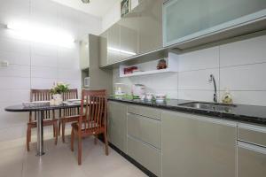 a kitchen with a sink and a table with chairs at •Lovely Home•11Pax+4Bedrooms+Themed•Bukit Mertajam in Bukit Mertajam