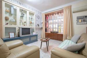 a living room with a couch and a tv at •Lovely Home•11Pax+4Bedrooms+Themed•Bukit Mertajam in Bukit Mertajam