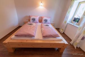 una camera con 2 letti con cuscini rosa di Apartment Gehrenspitze a Reutte