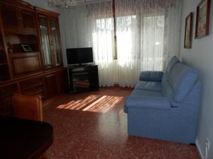 sala de estar con sofá azul y TV en Casa Con Encanto En Arnedillo, en Arnedillo
