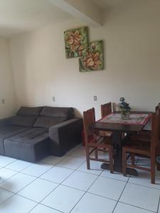a living room with a couch and a table at Casa de Praia Navegantes - 100 metros do mar in Navegantes