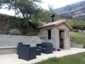 San Juan的住宿－La Estiva，石头壁炉,配有两把椅子和一张桌子