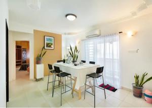 a dining room with a white table and chairs at Family Suite@DESA TEBRAU *IKEA *AEON *TESCO *HERO in Johor Bahru