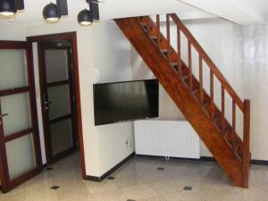 a living room with a tv and a staircase with a flat screen television at Amosa Liège City Centre Apart Gerardrie 23 in Liège