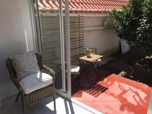 una sedia di vimini seduta su un balcone con un tavolo di Casa dos Limoeiros a Santiago do Cacém
