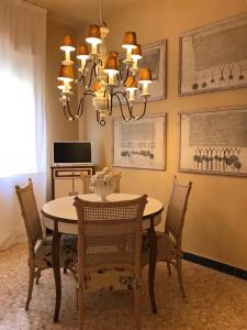 a dining room table with chairs and a chandelier at La Casa di Zia Rita in Porto SantʼElpidio