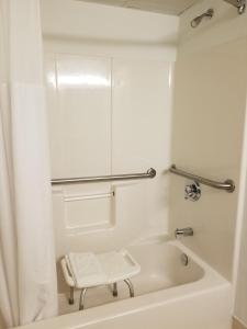 een wit bad met een kruk in de badkamer bij Country Inn & Suites by Radisson, Lexington, VA in Lexington