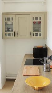 una cocina con armarios blancos y una placa amarilla en una encimera en Appartement avec vue panoramique en Vichy