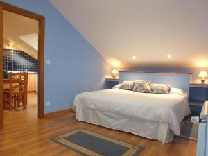 Un dormitorio con una cama grande con paredes azules. en Apartamentos Altamira, en Santillana del Mar