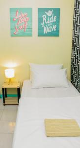 duas camas num quarto com dois cartazes na parede em Backpackers Homestay - NomadsMNL em Manilla