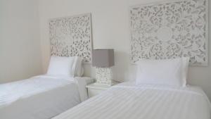 2 łóżka w białym pokoju z białymi ścianami w obiekcie Villa Ummangur 2 BR Private Villa Near Lovina w mieście Banjar