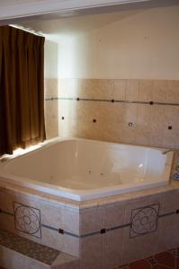 a large white bath tub in a bathroom at Mission Bell Motel in Ventura