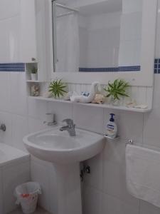 a white bathroom with a sink and a mirror at Private Apartments in Caribe Dominicus solo adultos in Bayahibe