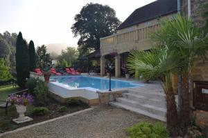 una piscina in un cortile accanto a una casa di Domaine Lacoste a Carsac-Aillac