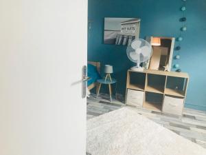 a room with a blue wall with a dresser and a mirror at CosyStudio2 Site du Futuroscope in Jaunay-Marigny