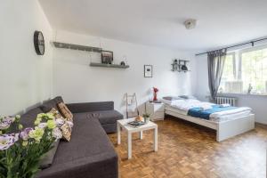 a living room with a couch and a bed at Noctis Apartment Powiśle in Warsaw