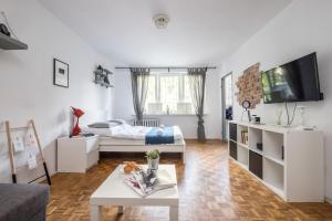 a white living room with a bed and a table at Noctis Apartment Powiśle in Warsaw