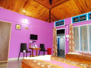 een kamer met paarse muren en een tafel en stoelen bij Eagle Nest Home Stay in Guwahati