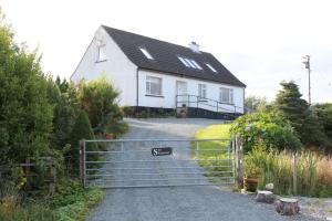 una casa blanca con una puerta delante de ella en Sea Shimmer en Portree