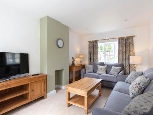 a living room with a couch and a tv at Meadow View in Cirencester