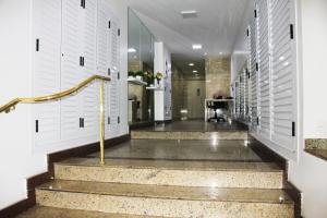 a hallway with white doors and stairs with gold railings at Apartamento Vista Mar in Rio de Janeiro