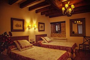 a bedroom with two beds and a mirror at Casería el Hondrígu in Mestas del Con