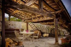 a patio with a table and chairs in a building at Casería el Hondrígu in Mestas del Con