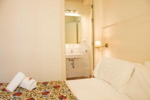 a small bathroom with a bed and a sink at Hostal Callejon del Agua in Seville +107 photos