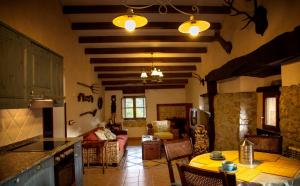 a kitchen and living room with a table and chairs at Casería el Hondrígu in Con