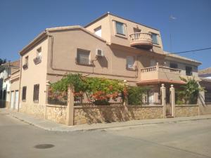 una grande casa con una recinzione in pietra di fronte ad essa di Amplia y luminosa buhardilla & total independencia a La Roda