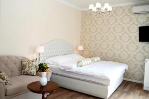 una camera con un letto bianco e un divano di Banica Apartments & Rooms a Spalato (Split)