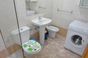 a bathroom with a toilet sink and a washing machine at Armonía Beach 17 in Arinaga