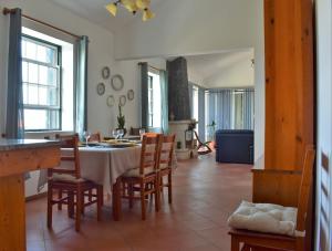 a kitchen and dining room with a table and chairs at Casa das Ondas in São Roque do Pico