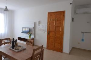 a dining room with a table and a wooden door at Armonía Beach 17 in Arinaga