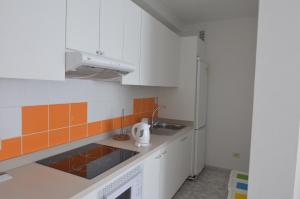 a white kitchen with a sink and a refrigerator at Armonía Beach 17 in Arinaga
