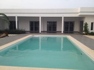a large blue swimming pool in front of a building at Villa contemporaine au calme sans vis à vis piscine privée in Somone