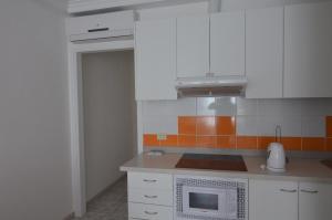 a kitchen with white cabinets and a microwave at Armonía Beach 17 in Arinaga