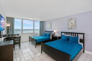 Una habitación de hotel con dos camas y un escritorio. en Miami Beach Apartments by MiaRentals, en Miami Beach 52 fotos más