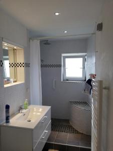 a white bathroom with a sink and a shower at Süderdeich in Koldenbüttel