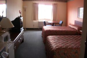 a hotel room with two beds and a television at Lodi Valley Suites in Lodi