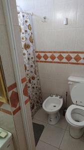 a bathroom with a toilet and a shower curtain at Departamentos céntricos con parrilla in Punta Alta