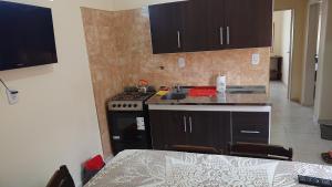 a kitchen with a stove and a sink and a table at Departamentos céntricos con parrilla in Punta Alta +3 photos